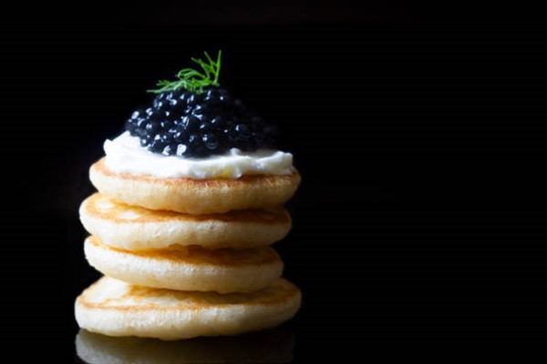 Black caviar blinis with cream cheese and fresh dill.